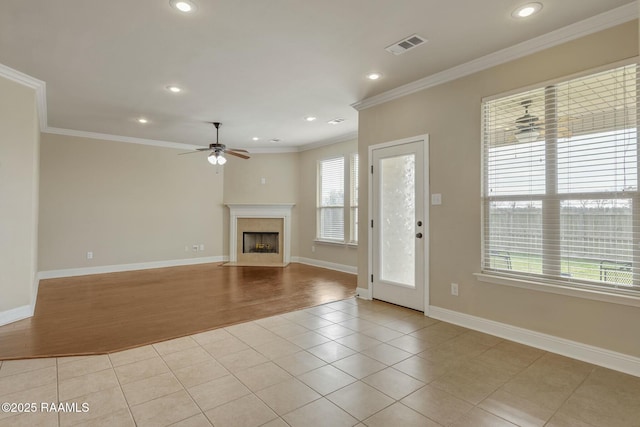 unfurnished living room featuring ceiling fan, ornamental molding, and light tile patterned floors