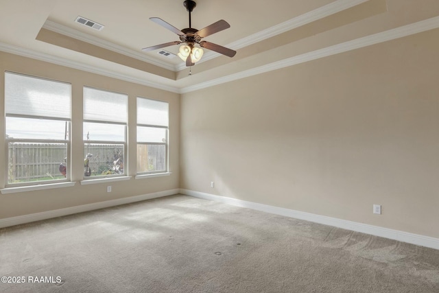 carpeted spare room featuring a raised ceiling, crown molding, and ceiling fan