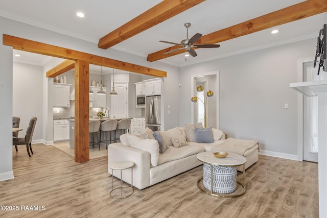 living room with ceiling fan, ornamental molding, sink, and light hardwood / wood-style floors