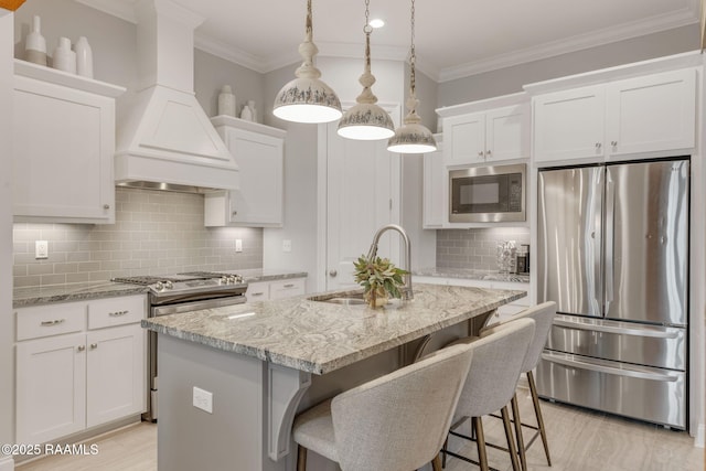 kitchen with stainless steel appliances, custom exhaust hood, sink, and white cabinets