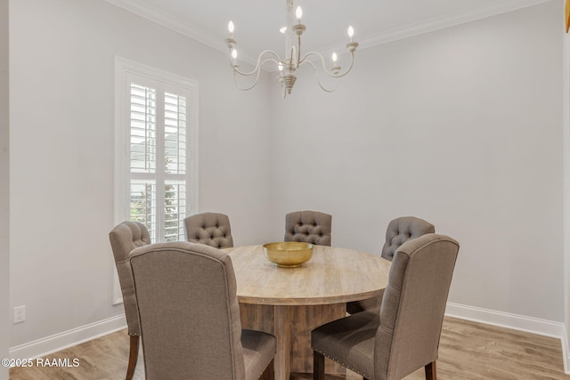 dining room featuring an inviting chandelier, ornamental molding, and light hardwood / wood-style flooring