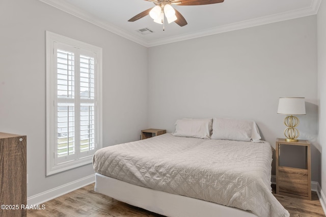 bedroom featuring hardwood / wood-style flooring, ornamental molding, and ceiling fan