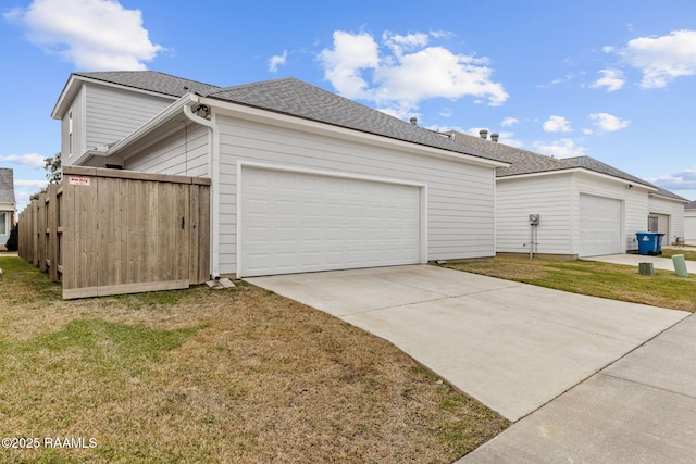 view of side of property featuring a garage and a lawn