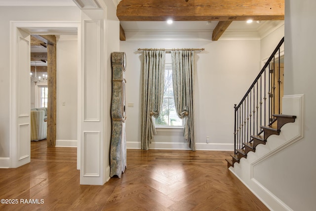 foyer entrance featuring beamed ceiling and ornamental molding