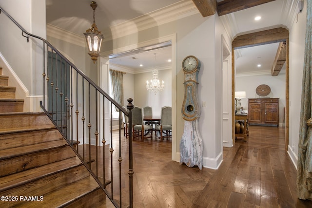 entryway featuring a chandelier, dark hardwood / wood-style floors, and ornamental molding