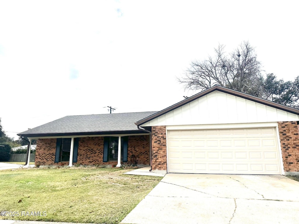 ranch-style house with a garage and a front lawn