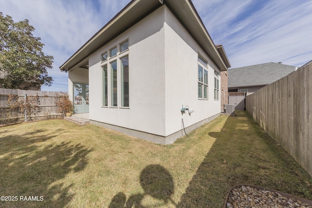 view of side of home with a yard and central air condition unit