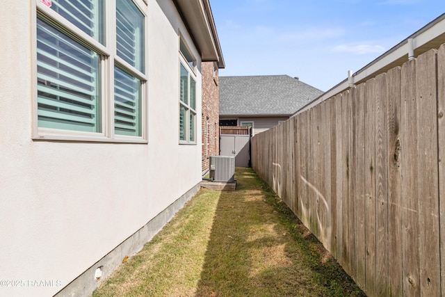 view of side of home with a yard and central AC unit