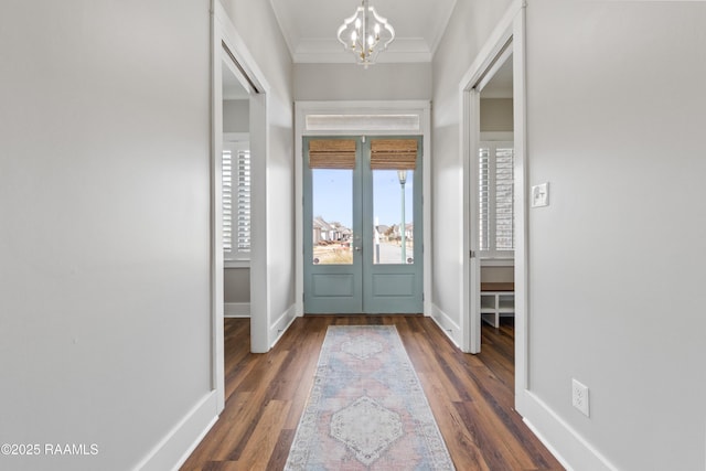 doorway with an inviting chandelier, ornamental molding, dark hardwood / wood-style floors, and french doors