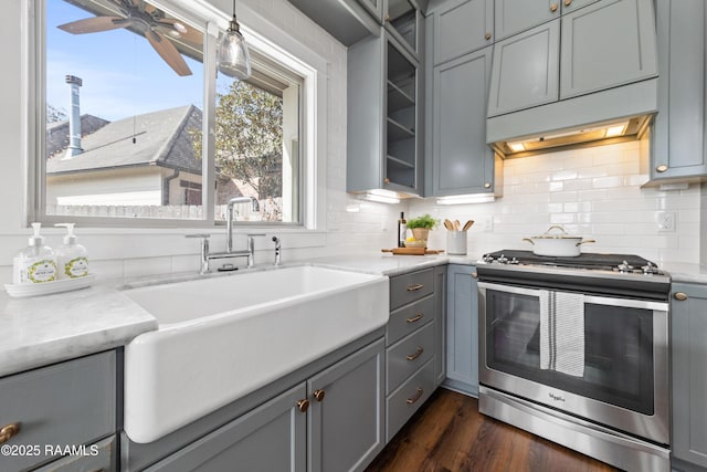 kitchen featuring tasteful backsplash, sink, gray cabinetry, stainless steel range, and light stone counters