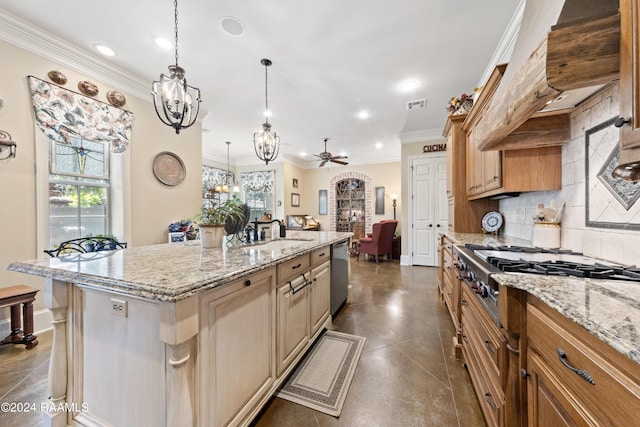 kitchen featuring decorative light fixtures, sink, ornamental molding, stainless steel appliances, and a center island with sink