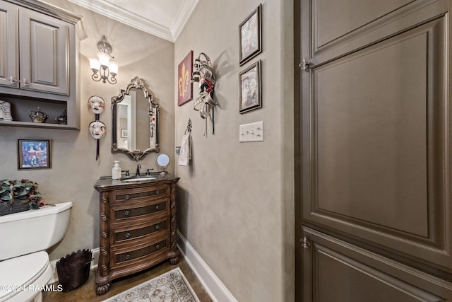 bathroom featuring ornamental molding, toilet, and vanity