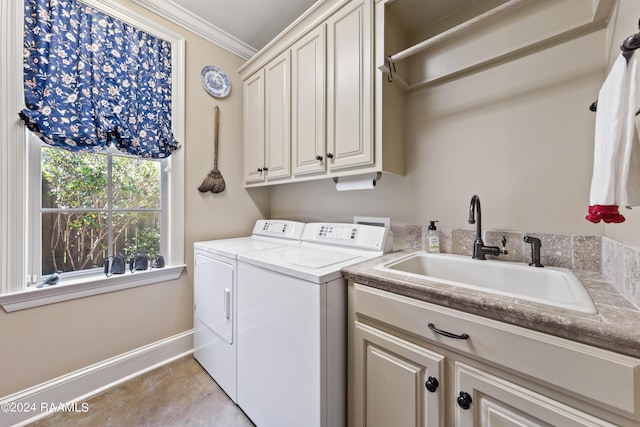 laundry area with sink, ornamental molding, washing machine and dryer, and cabinets