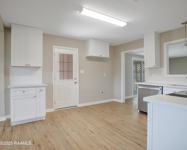 kitchen featuring hanging light fixtures, stainless steel dishwasher, white cabinets, and backsplash