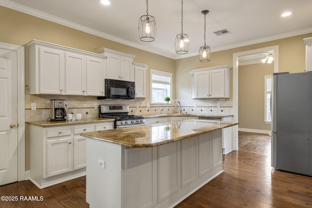 kitchen featuring a kitchen island, white cabinetry, appliances with stainless steel finishes, and sink