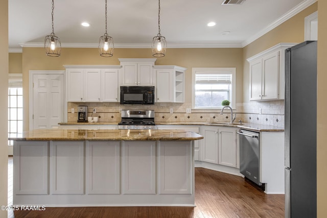 kitchen with stainless steel appliances, a kitchen island, and white cabinets