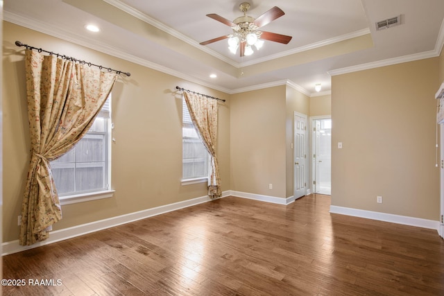 spare room featuring hardwood / wood-style floors, a raised ceiling, and ceiling fan