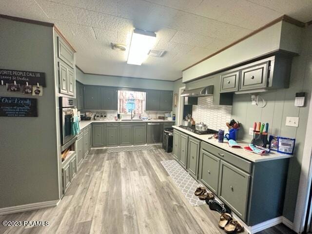 kitchen featuring sink, tasteful backsplash, black gas cooktop, oven, and light hardwood / wood-style floors