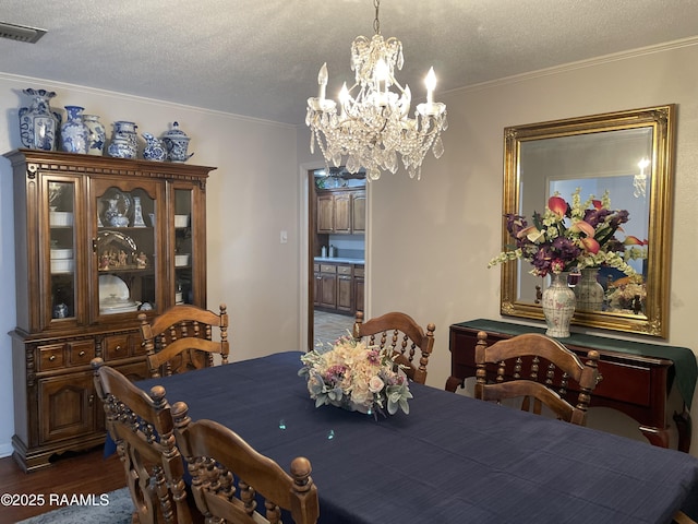 dining room featuring ornamental molding, dark hardwood / wood-style floors, and a textured ceiling