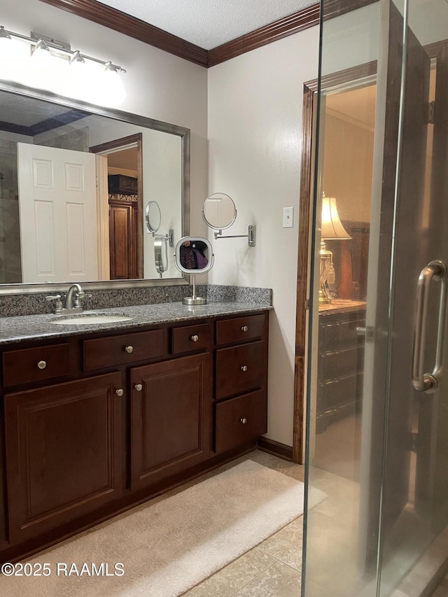 bathroom featuring vanity, ornamental molding, and a textured ceiling