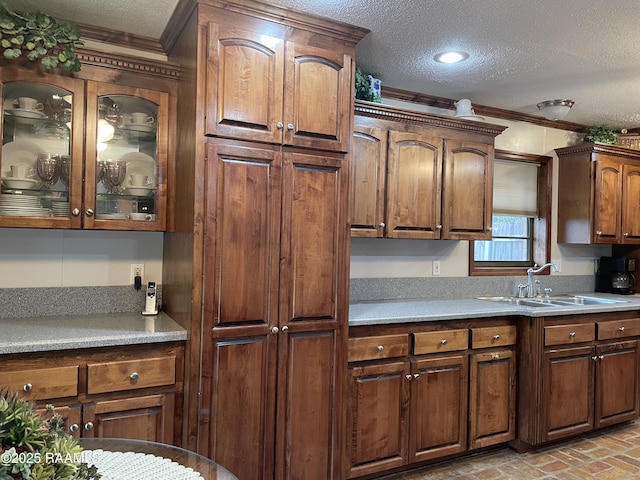 kitchen featuring sink, crown molding, and a textured ceiling