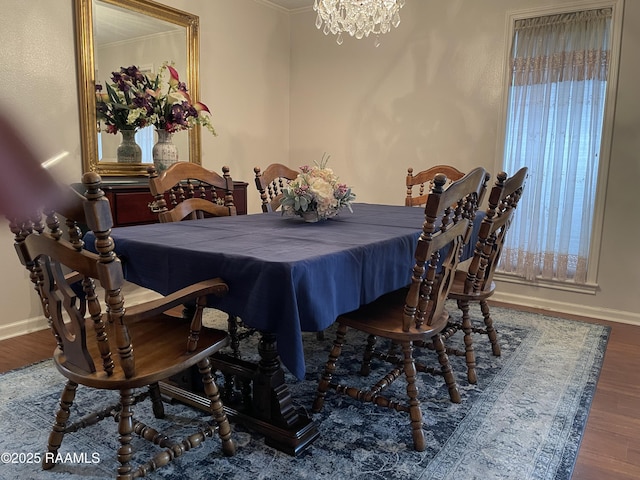 dining area with hardwood / wood-style flooring, crown molding, and a notable chandelier