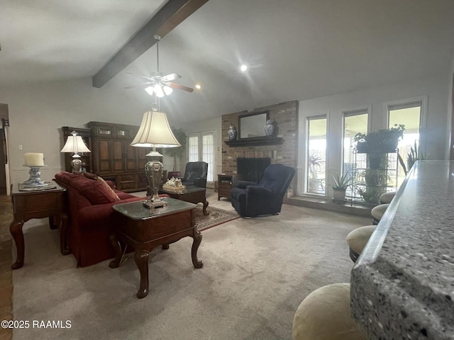 living room featuring lofted ceiling with beams, ceiling fan, carpet, and a fireplace