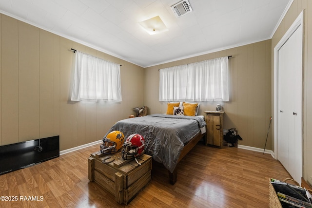 bedroom featuring ornamental molding, light hardwood / wood-style floors, and a closet