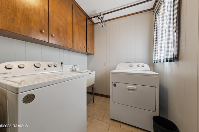 laundry room with light tile patterned flooring, sink, wood walls, cabinets, and separate washer and dryer