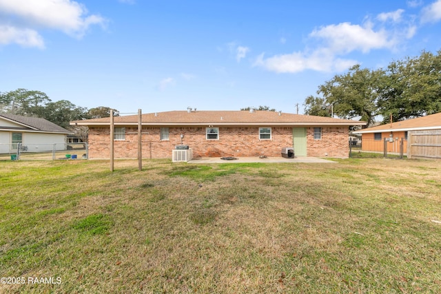 back of house featuring central AC, a patio area, and a lawn