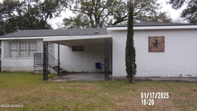 rear view of property featuring a yard and a patio area