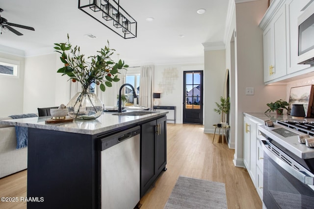 kitchen with sink, appliances with stainless steel finishes, a kitchen island with sink, white cabinetry, and light hardwood / wood-style floors