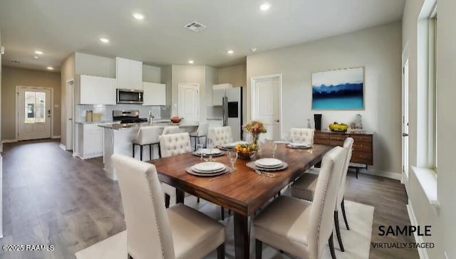 dining room with sink, dark wood-type flooring, and plenty of natural light