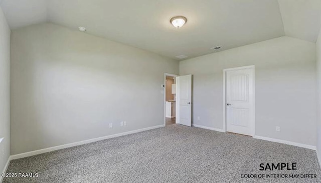 unfurnished bedroom featuring lofted ceiling and carpet