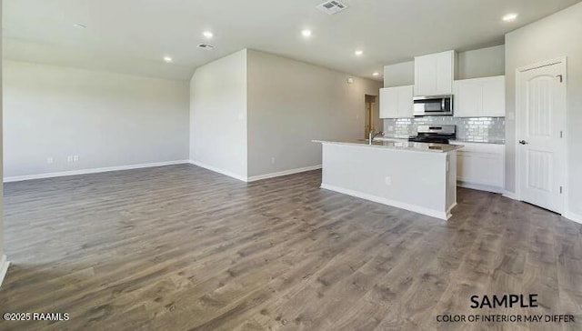 kitchen with a center island with sink, appliances with stainless steel finishes, dark hardwood / wood-style floors, white cabinets, and backsplash