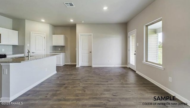 kitchen featuring sink, dark wood-type flooring, tasteful backsplash, white cabinets, and stone countertops