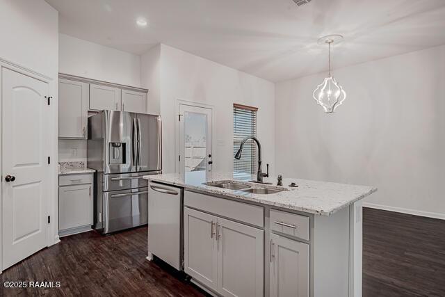 kitchen featuring sink, appliances with stainless steel finishes, gray cabinetry, a center island with sink, and decorative light fixtures