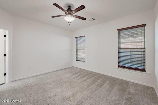 carpeted spare room with ceiling fan