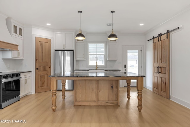 kitchen featuring white cabinets, stainless steel fridge, a kitchen island, and electric range