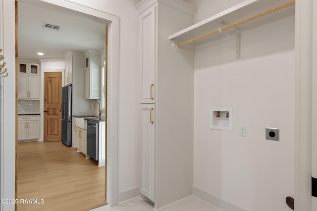 laundry room featuring washer hookup, hookup for an electric dryer, sink, and light wood-type flooring