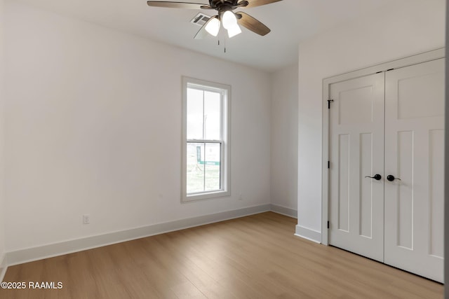 unfurnished bedroom with a closet, ceiling fan, and light wood-type flooring