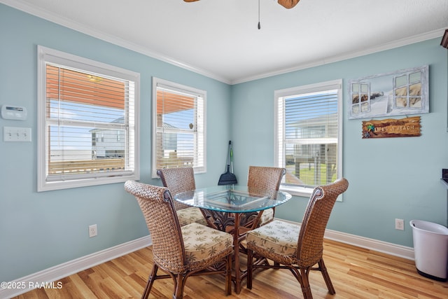 dining area with crown molding, a wealth of natural light, and light hardwood / wood-style floors