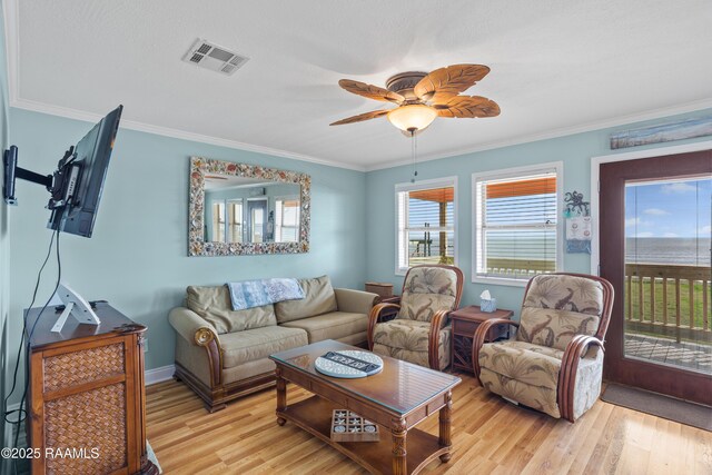 living room with ornamental molding, ceiling fan, and light hardwood / wood-style floors