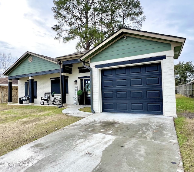 view of front facade featuring a garage, covered porch, and a front lawn