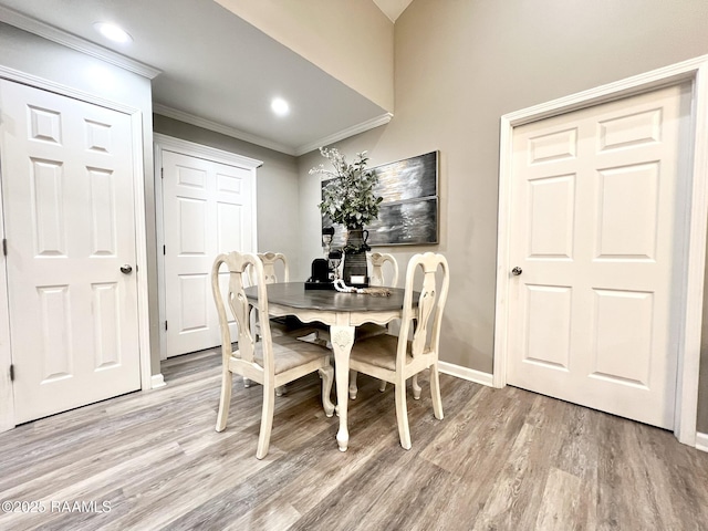 dining area with crown molding and light hardwood / wood-style floors