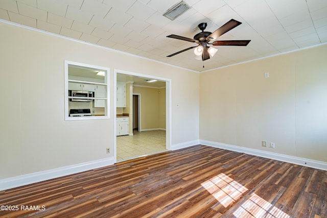 empty room with wood-type flooring, ornamental molding, and ceiling fan