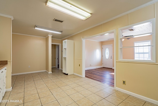 tiled foyer featuring crown molding