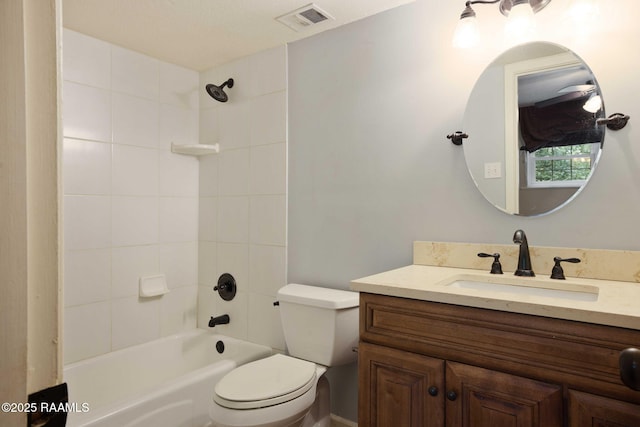 full bathroom featuring tiled shower / bath, vanity, and toilet