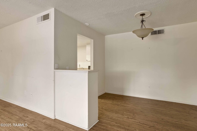 empty room featuring dark hardwood / wood-style floors and a textured ceiling