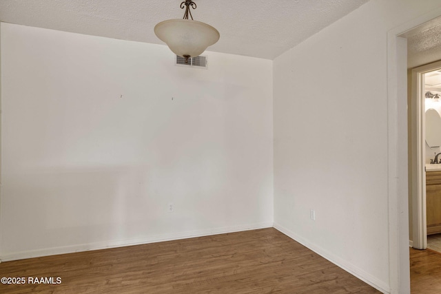 spare room with wood-type flooring and a textured ceiling